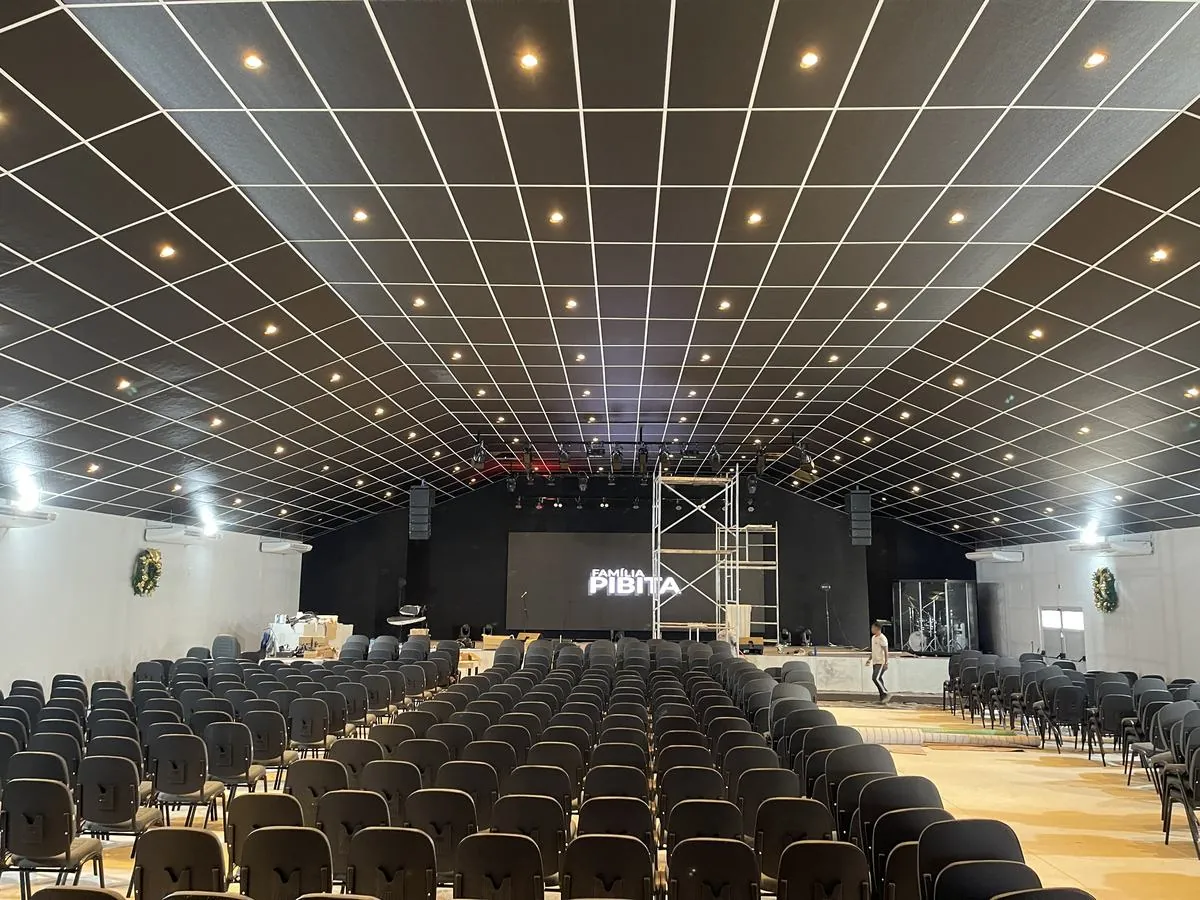 Auditório principal com forro em grelha e iluminação embutida, obra executada pela MCL Construtora